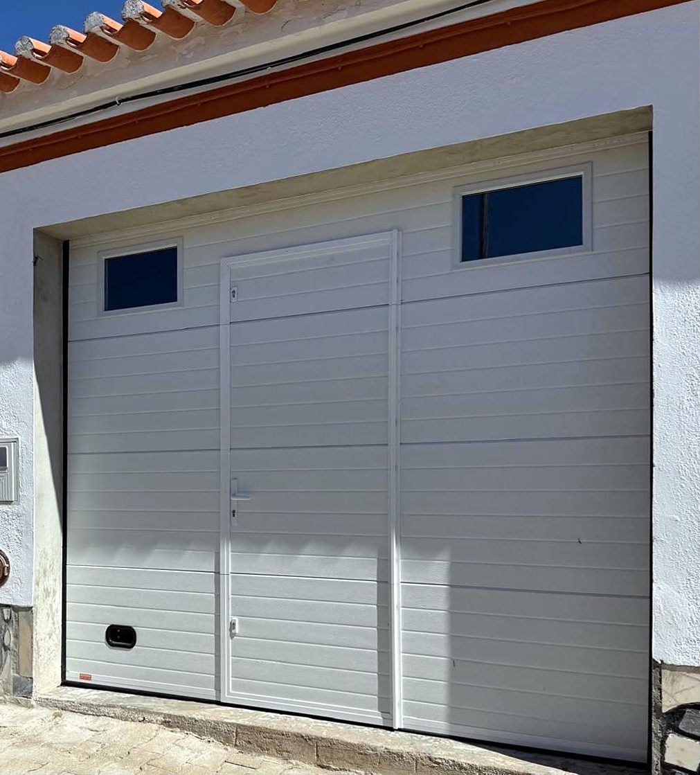 Porta seccionada branca com porta pedonal e janelas
